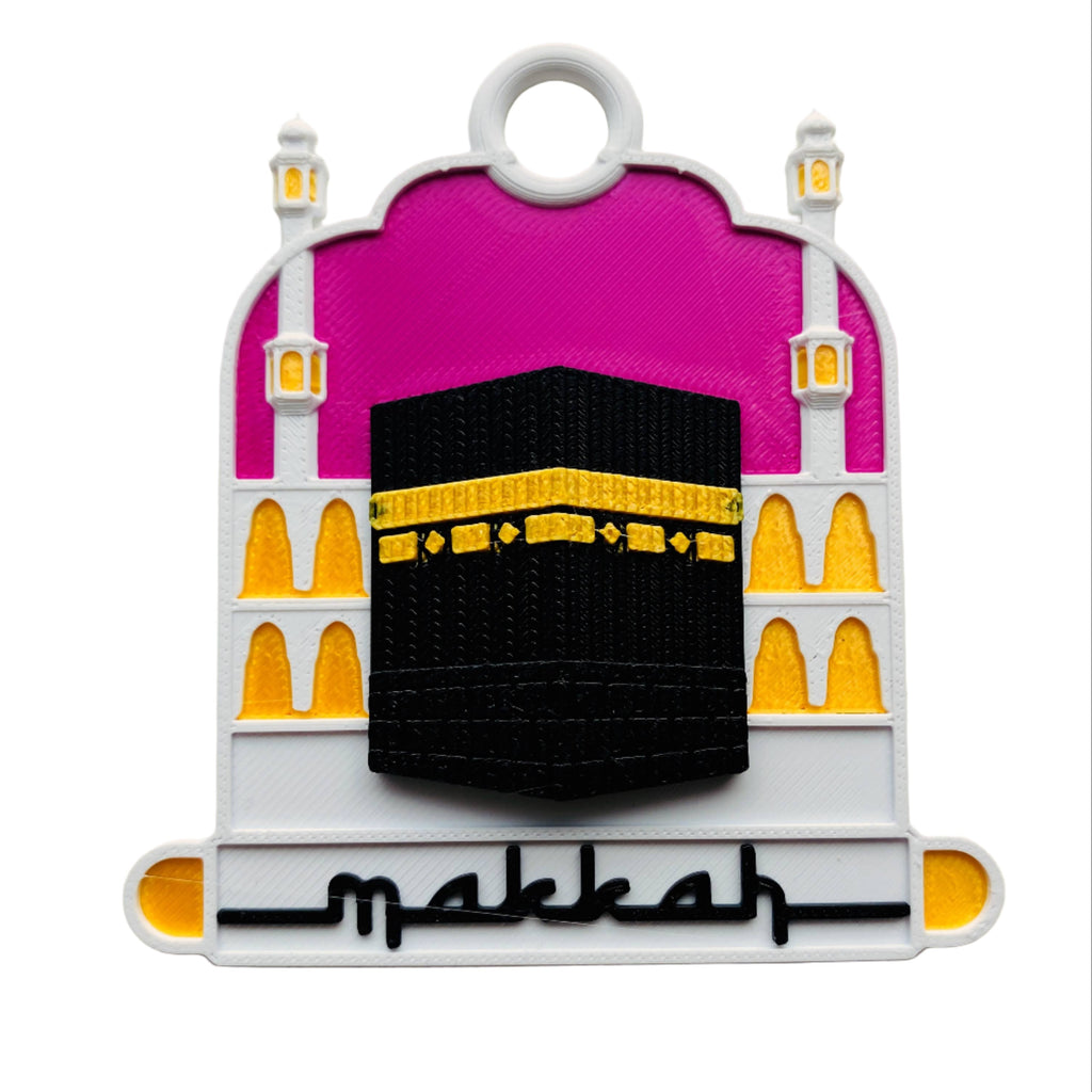 Decorative key tag with a pink arch, black Kaaba, and yellow accents on a beige background